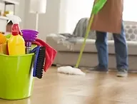 Image d'un seau avec des produits d'entretien, et d'une personne passant la serpillière